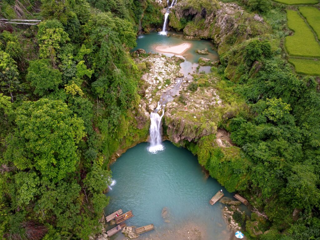 A stunning aerial view of cascading waterfalls surrounded by lush greenery and turquoise pools.